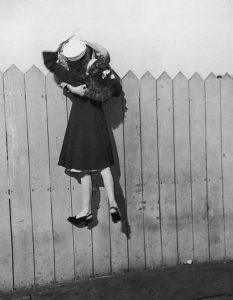 Un soldato si sporge da una staccionata e solleva la sua fidanzata per baciarla (1945) Hulton Archive
